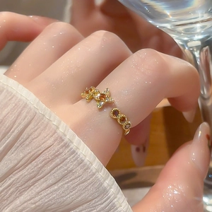 Detailed close-up of 18k gold plated star and flower ring with sparkling cubic zirconia