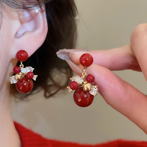 Detail view of red beaded fireworks earrings with gold plating and sparkling zircons