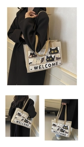 Detail of beige canvas tote bag with black and white cat comic illustration and Welcome print