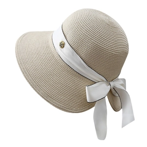 Elegant beige straw sun hat with black-trimmed white ribbon bow and gold rose badge