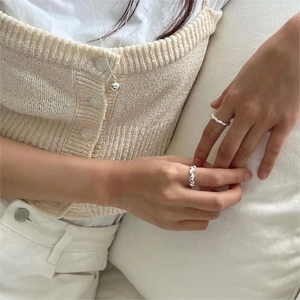 Close-up of minimalist S925 sterling silver heart ring and pendant on a model