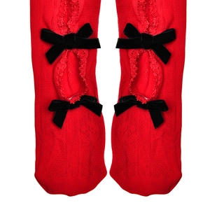 Vue détaillée de chaussettes en tricot rouge avec bordure en dentelle et nœuds noirs