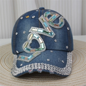 Detailed view of dark denim baseball cap with sparkling rhinestone LOVE letter patterns