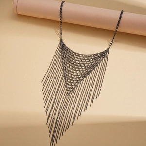 Détail de la maille en métal sombre et des pompons en chaîne sur un collier imposant