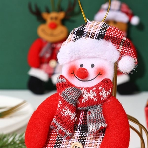 Close-up of fabric snowman ornament with red plaid hat and cozy Christmas textures
