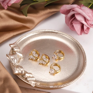 Elegant gold butterfly stud earrings and heart zircon hoops on luxury tray