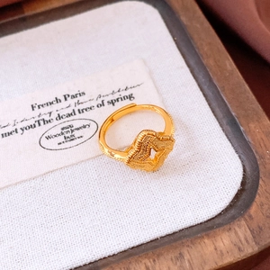 Macro view of vintage gold-plated clover ring featuring fine frosted texture and open design
