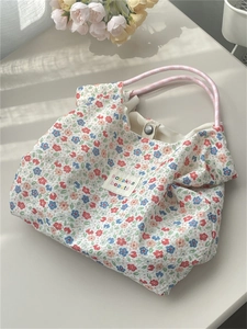 Detail of floral canvas tote with metal snap closure and chic fabric brand label