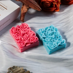 Dettaglio di saponi con rose su raso bianco con decoro floreale e luce elegante