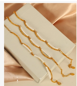 Detail of double-layer pearl bracelet with 18K gold plated irregular metal charms