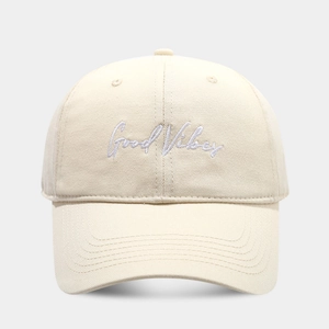 Detail of Good Vibes white embroidery on creamy cotton twill baseball cap with stitching