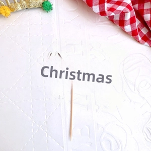Blue and white Merry Christmas cake topper with reindeer antlers and a wooden stick