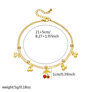 Gold double-layered anklet with red cherry charms and crystal accents on white background