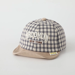 Close-up of beige plaid baby cap with Brooklyn embroidery and soft fabric texture