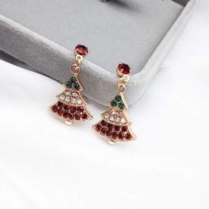 Detailed macro of festive Christmas tree earrings with colored rhinestones on velvet