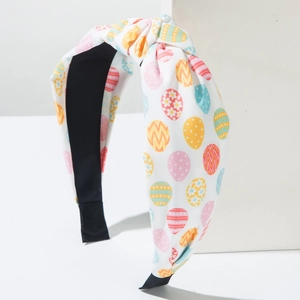 Detail of Easter knotted headband featuring colorful hand-drawn egg patterns on white fabric