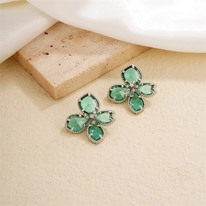 Élégantes boucles d'oreilles fleur vert émeraude avec cristal sur fond luxueux