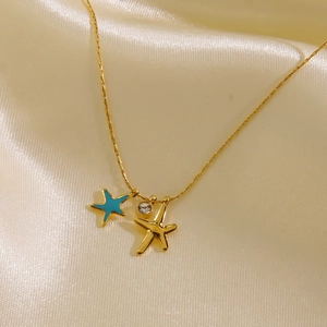 Detail view of gold starfish necklace with blue enamel pendant and sparkling zircon stone