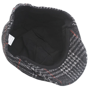 Detail view of newsboy cap interior showing houndstooth pattern and care label