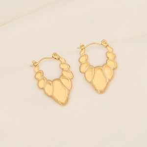 Irregular geometric gold stainless steel star earrings on a textured cream fabric background