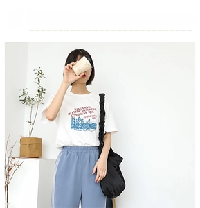 Detailed view of a black pleated nylon shoulder bag paired with a casual white t-shirt