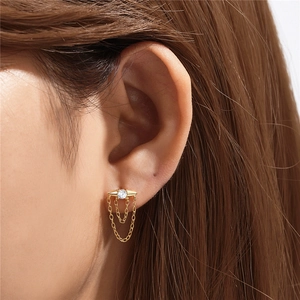 Detail of s925 silver gold eye stud earring with diamond accents and chain tassels