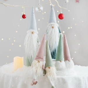 Plush Christmas gnome set in Morandi grey and pink on a white lace tablecloth