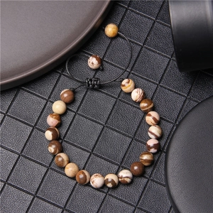 Macro shot of natural tiger eye stone beads on a black woven adjustable bracelet cord