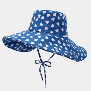 Detail of navy blue sun hat with pink heart patterns and matching tie ribbon bow
