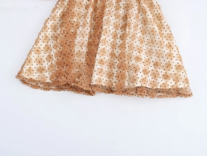 Dettaglio gonna in tulle beige con rose 3D a vortice e motivi a pois neri fini