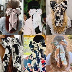 Various floral print oversized bow hair clips shown as worn styles for women