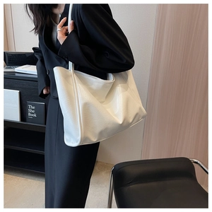 Vue détaillée d'un grand sac cabas blanc porté à l'épaule pour les trajets quotidiens