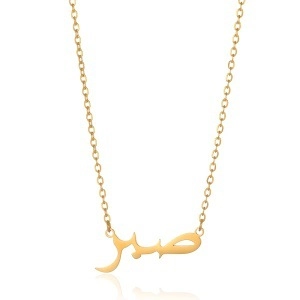 Detail of gold Arabic Sabr calligraphy pendant on a delicate stainless steel chain