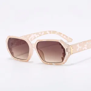 Irregular cream marble sunglasses with brown gradient lenses and gold cross detail