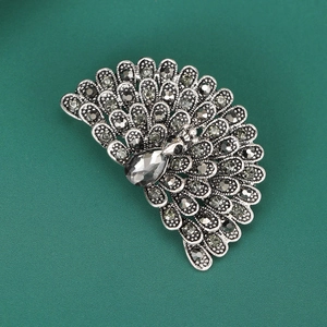Macro detail of silver peacock brooch featuring sparkling grey water-drop crystal rhinestones