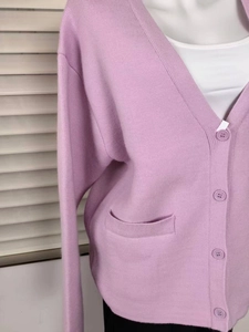Detail of lilac V-neck cardigan featuring textured knit and matching tone buttons