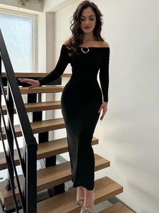 Close-up of the elegant gold ring detail on the neckline of a black knit dress
