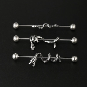 Detailed view of three stainless steel industrial barbells with gothic snake designs