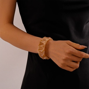 Macro detail of amber resin geometric pyramid bracelet on model wrist with modern style
