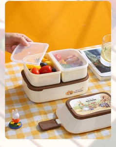 Detail of double-layer rabbit lunch box being opened on a plaid tablecloth