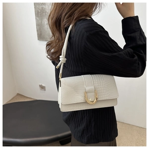Detail of white crocodile pattern PU leather underarm bag with gold U-shaped buckle
