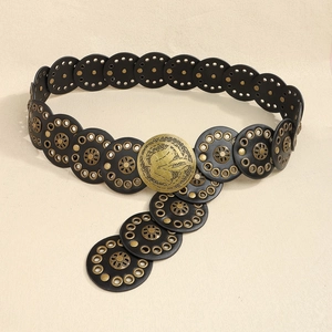 Detail of a black punk leather belt with vintage brass studs and Phoenix floral buckle