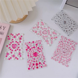 Close-up of DIY crystal gem stickers with colorful acrylic hearts and pearls on white