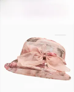 Detail of khaki organza sun hat with large mesh bow and floral print for beach outings