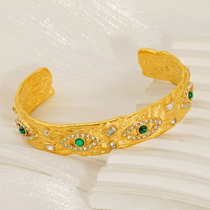 Detail der goldenen Evil Eye Manschette mit gehämmerter Textur und Malachitsteinen