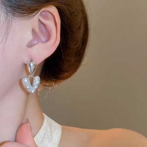 Vue détaillée de boucles d'oreilles en zircon étincelant en forme de cœur sur un modèle