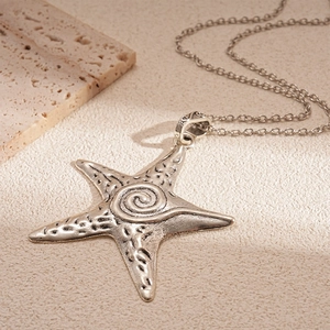 Vintage silver starfish pendant necklace with embossed spiral texture on a metal O-chain