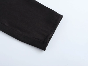 Détail de la manchette en maille côtelée noire avec coutures précises sur la robe