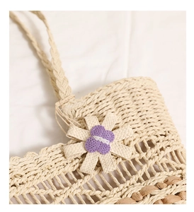 Detail of straw bag weaving with beige 3D flower and purple heart-shaped center