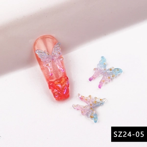 Detailed macro view of 3D aurora resin butterfly nail charms with gold glitter